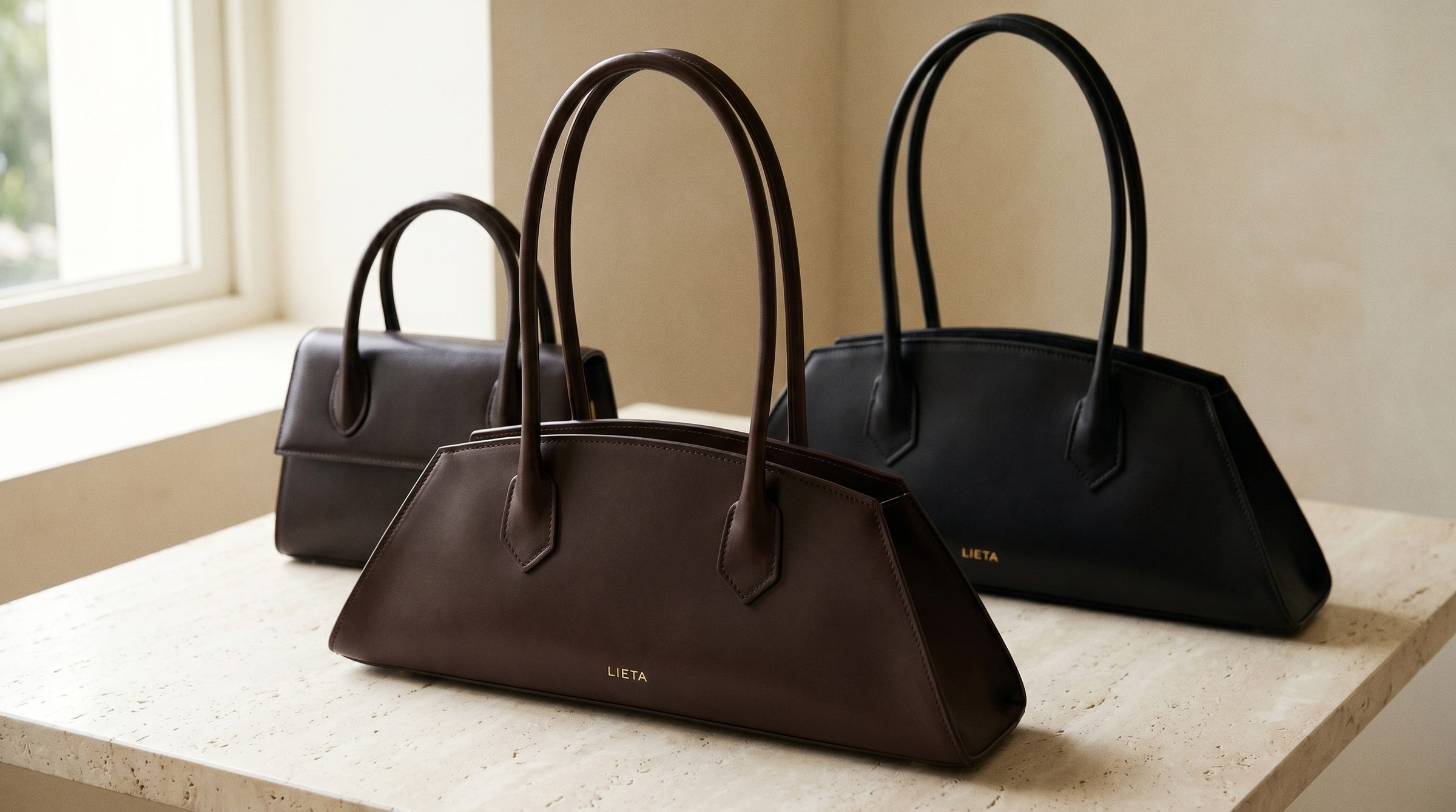 The Lungo in black Italian Buttero leather on a near-white studio background — a structured silhouette in the same category as DeMellier's signature Mini Venice and Tokyo styles.